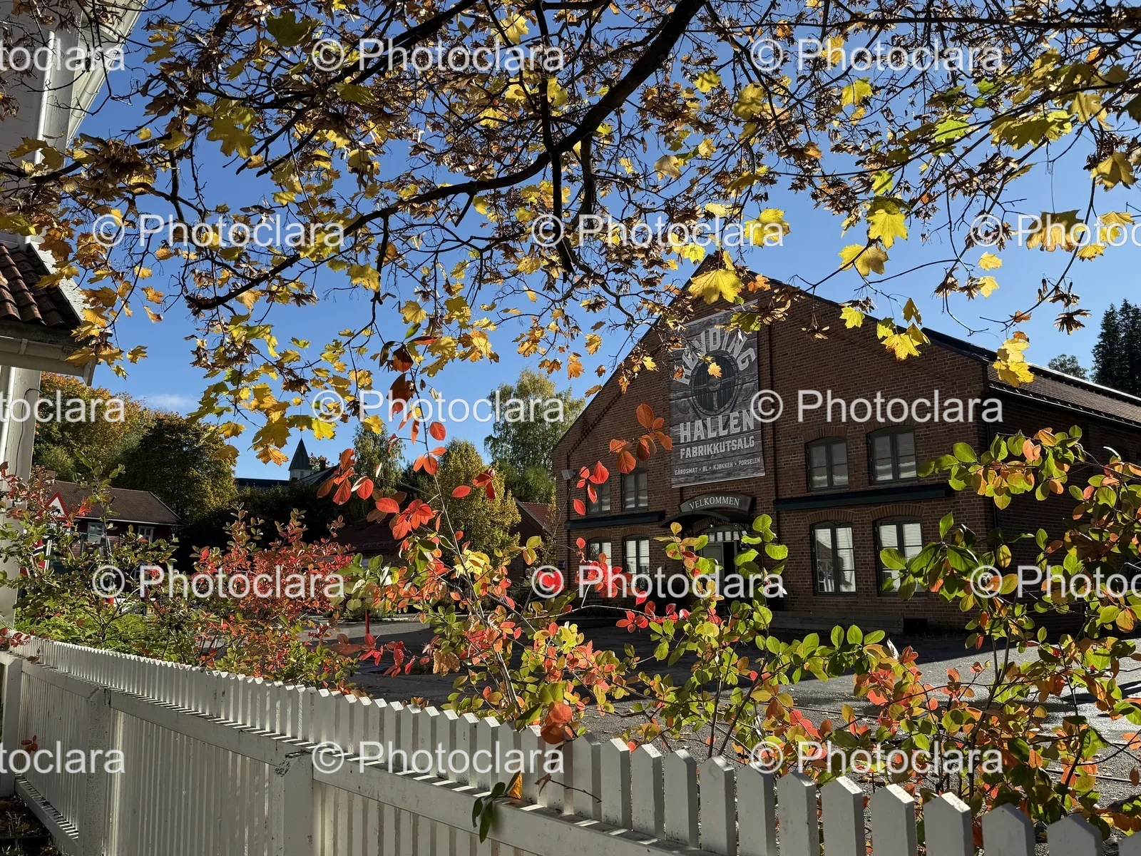 Charming Commercial Building with White Fence and Trees