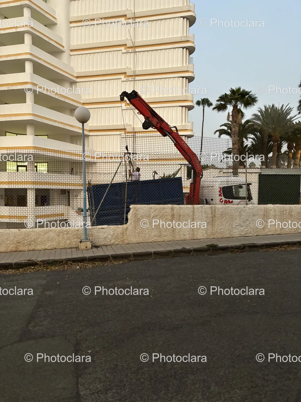 Crane-Near-Modern-Building-and-Fence.jpg