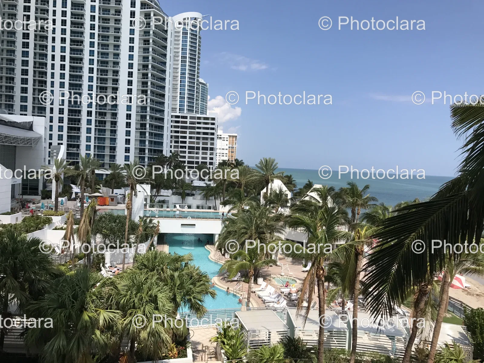 luxury-resort-pool-with-palm-trees-and-building-backdrop.jpg