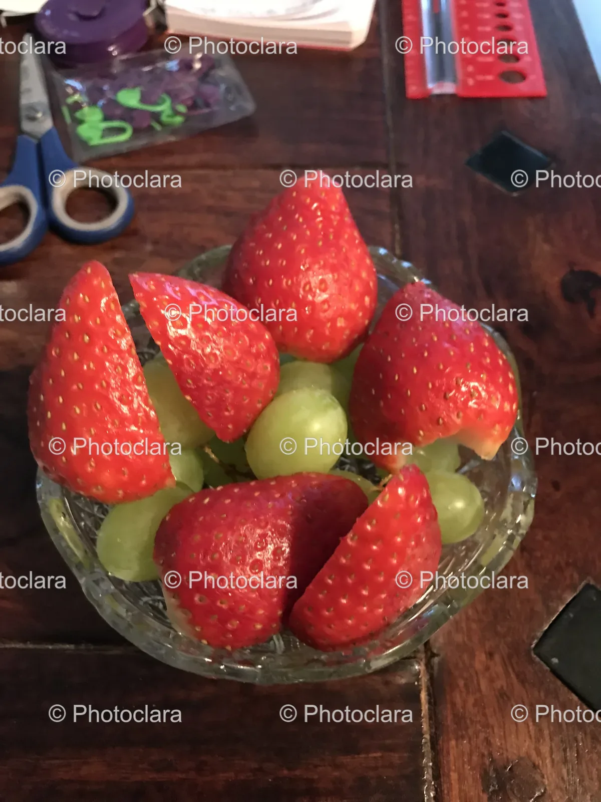 a-bowl-of-strawberries-and-grapes-on-a-wooden-table.jpg