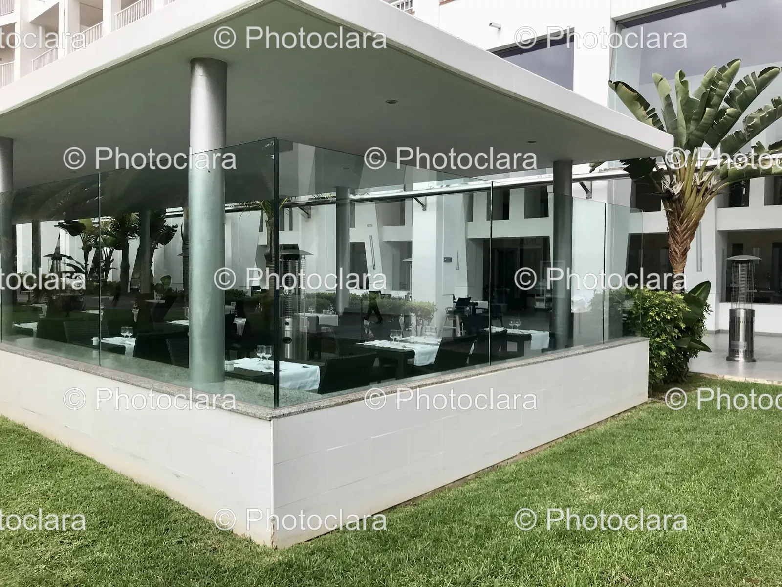 glass-covered-patio-area-white-building-green-grass.jpg