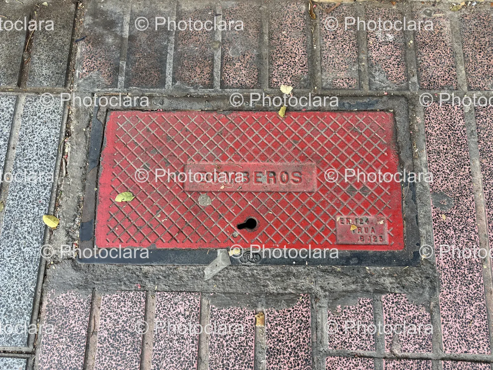 red-metal-manhole-cover-bomberos-brick-surface.jpg