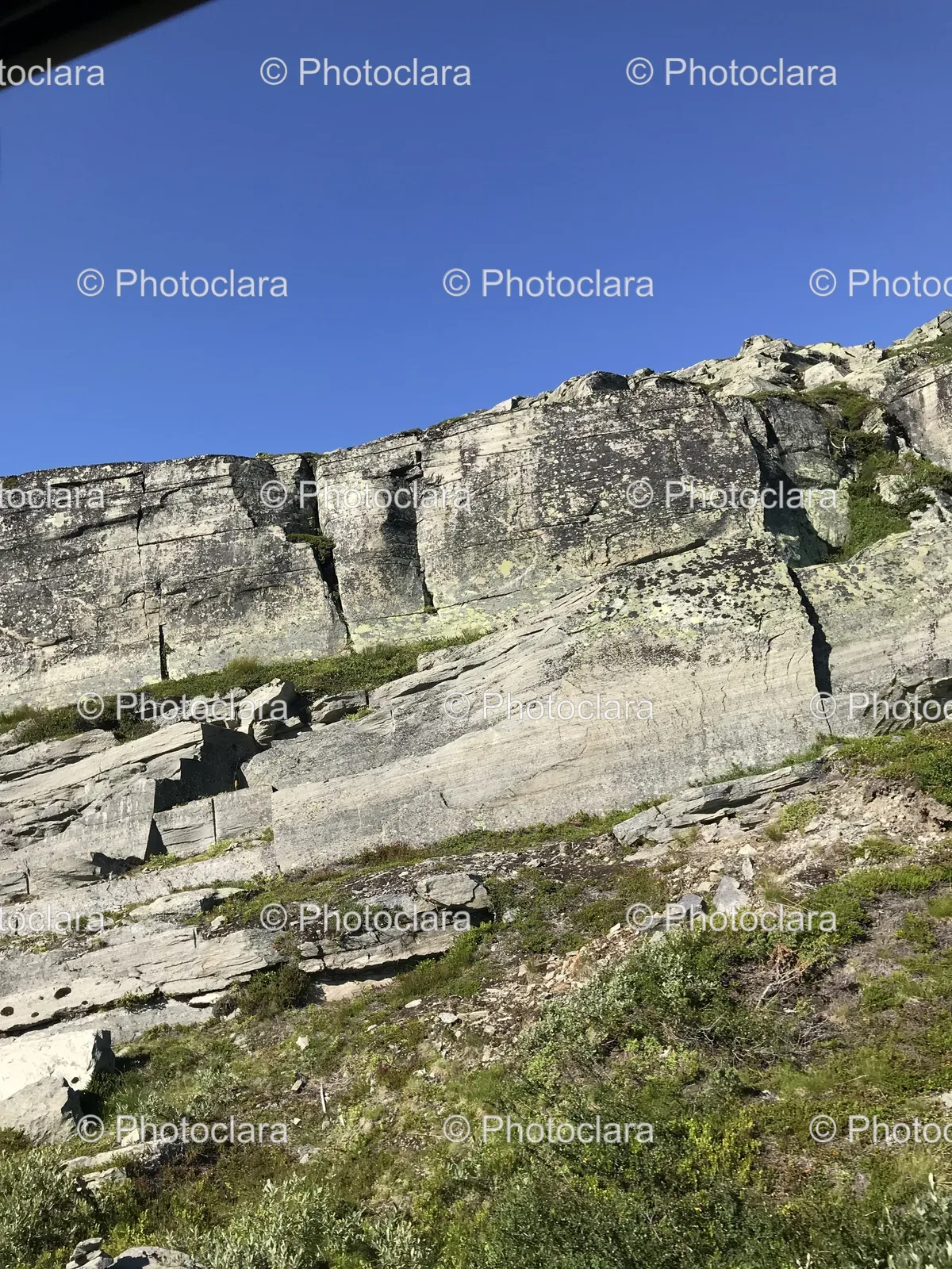rocky-cliff-with-grass-and-blue-sky.jpg