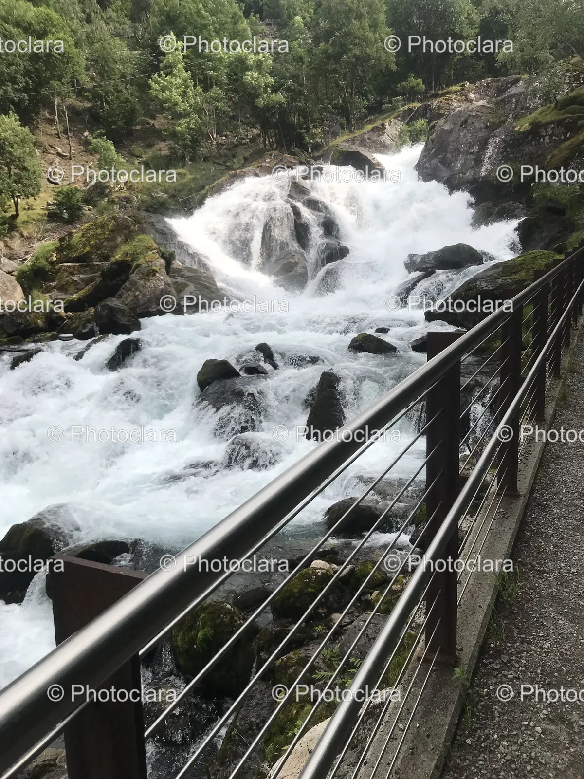 majestic-waterfall-with-rocks-and-railing.jpg