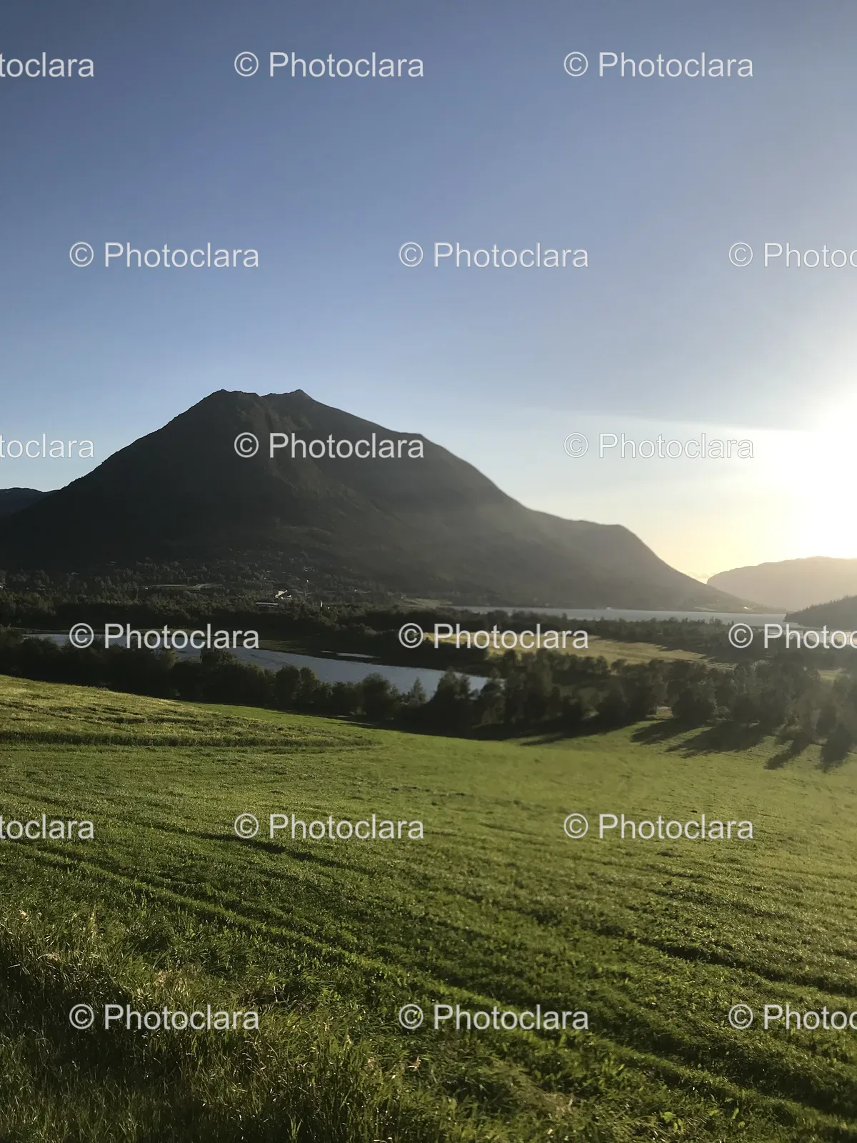 serene-green-field-with-river-and-mountain-views.jpg