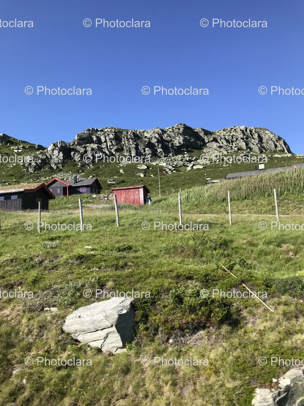 grassy-hill-with-fence-and-building.jpg