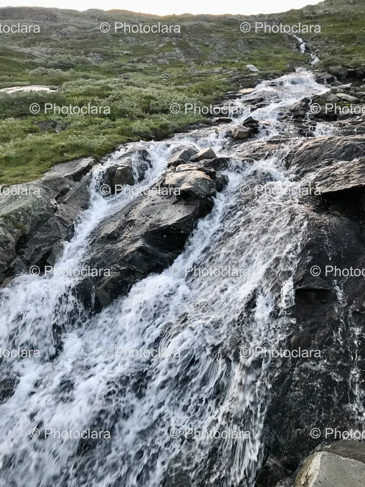 Majestic-Waterfall-Cascading-Over-Rocks-and-Grass.jpg