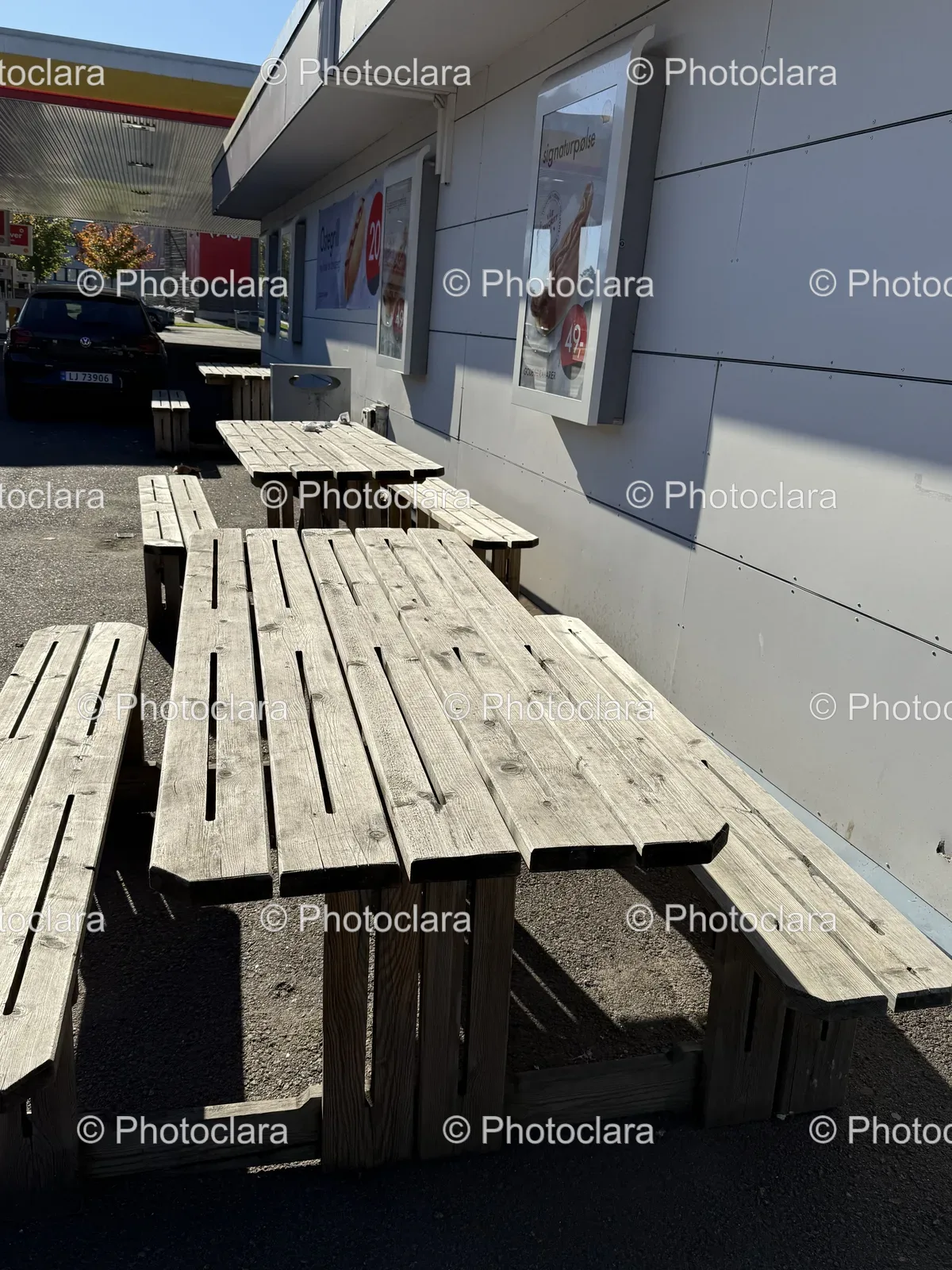 Sunlit-Wooden-Tables-Benches-Outdoor-Scene.jpg